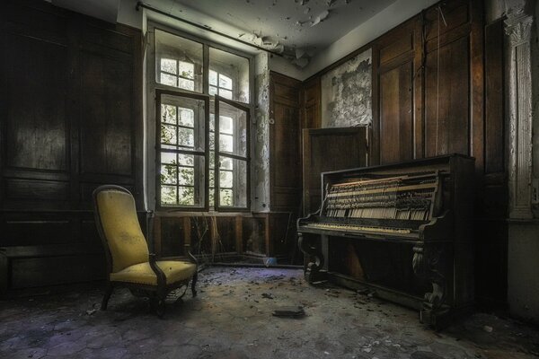 Fauteuil et piano dans une maison abandonnée