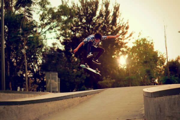 Der Skateboarder macht bei Sonnenuntergang eine Tanne