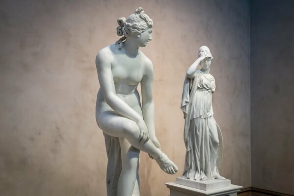 Deux sculptures de femmes sur fond de mur blanc