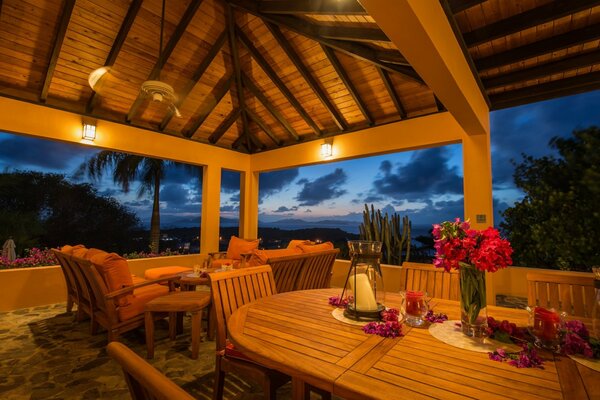 Covered wooden gazebo by the ocean in the light of lanterns