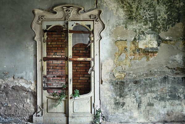 Bella porta bianca con vetro rotto in un edificio abbandonato