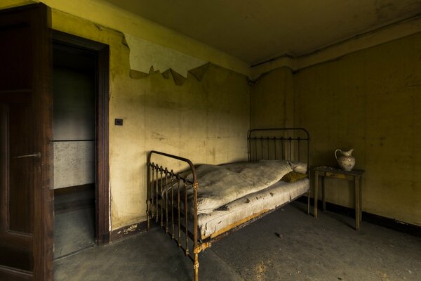 An old bed in a room with an open door