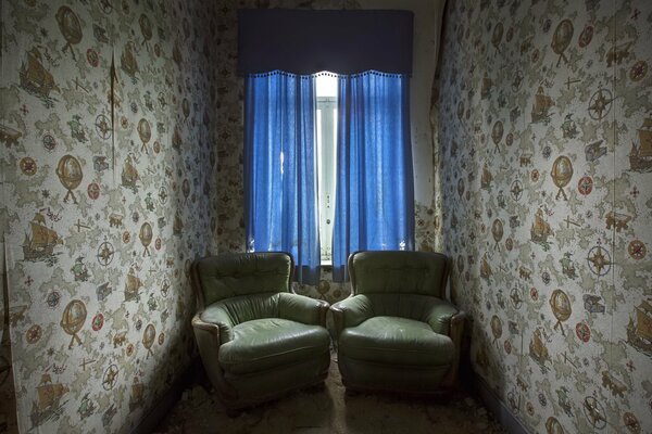 A narrow dark room with blue wallpaper