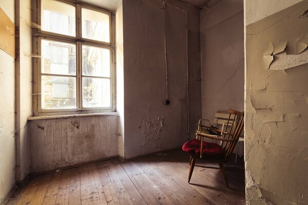 An old room with a large window and a chair