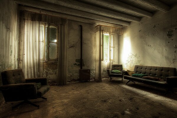 A room with old furniture and ruined wallpaper