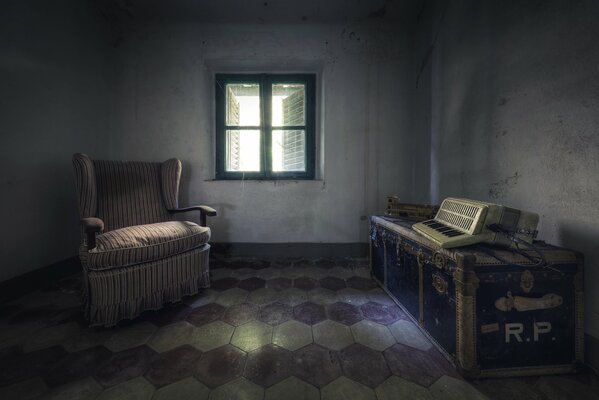 An old accordion in the room next to the chair