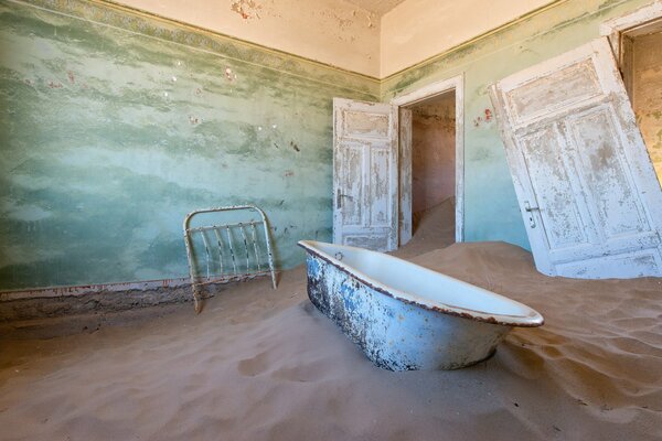 A bathtub in the sand a broken door