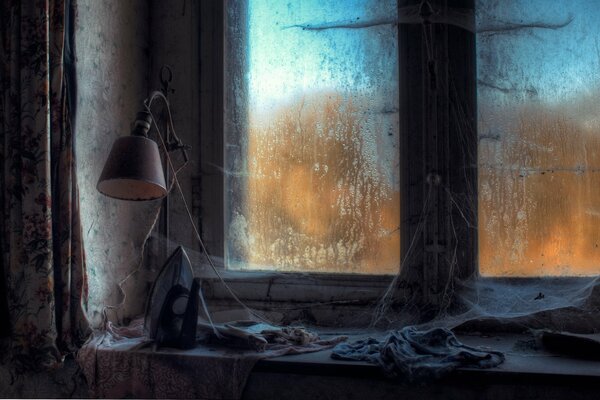 Lamp on a cobweb-covered window