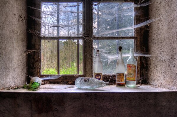 Bottles on the window with cobwebs