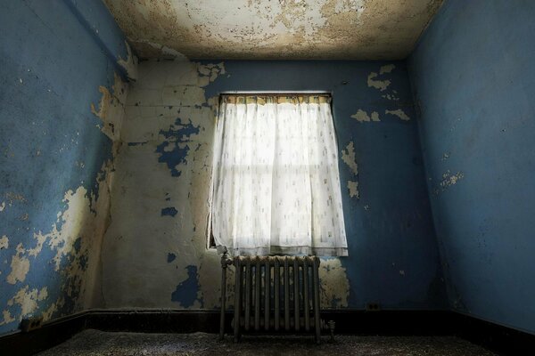 Las cortinas cuelgan solitarias en una habitación vacía