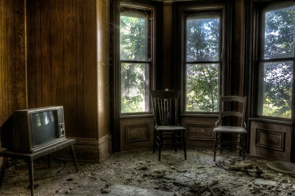 Chambre sombre avec vieilles chaises de télévision et fenêtres