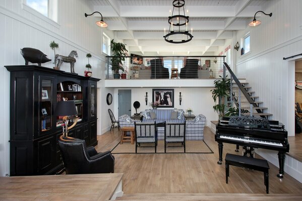 A huge living room with a black piano by the stairs