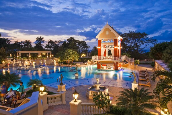 Hotel por la noche con gran piscina