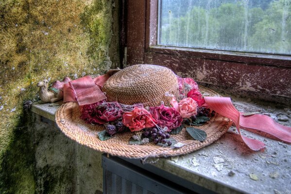 Hut mit Blumen auf Fensterhintergrund