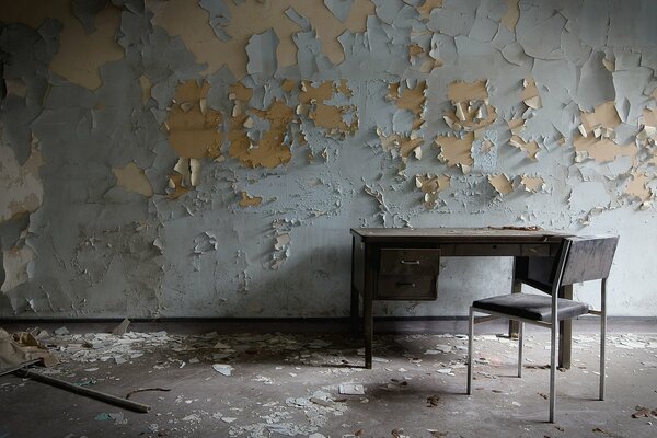 Sur le fond d un mur en lambeaux, une table et une chaise