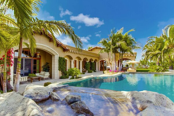 A chic mansion with a swimming pool and palm trees