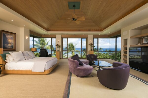 Bedroom with a view of the ocean and palm trees