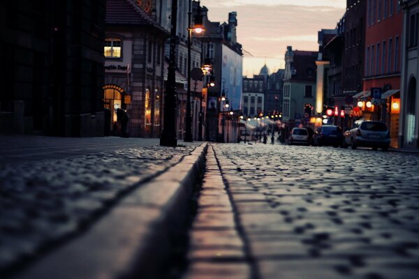 Night lights reflected on the stone paving stones of the city street