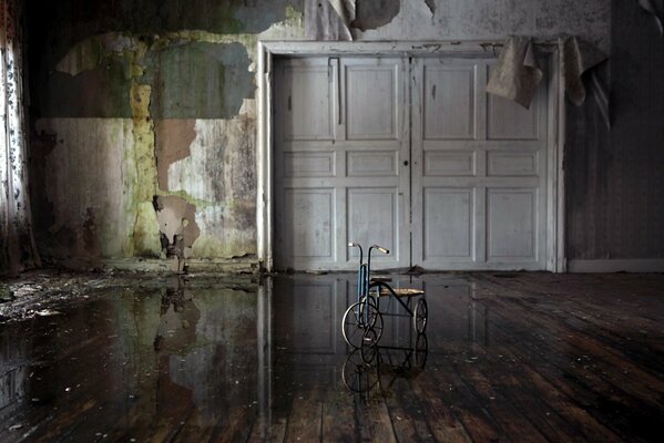 Habitación vacía sin papel tapiz, hay una bicicleta en el medio, las puertas están completamente cerradas