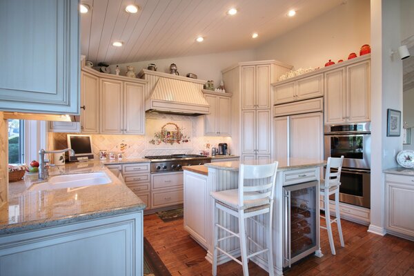 Modern wooden kitchen with high-legged chairs in white design