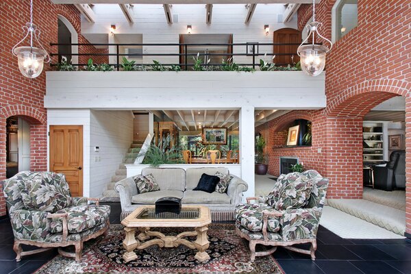 Thoughtful interior of a room with a second floor and masonry