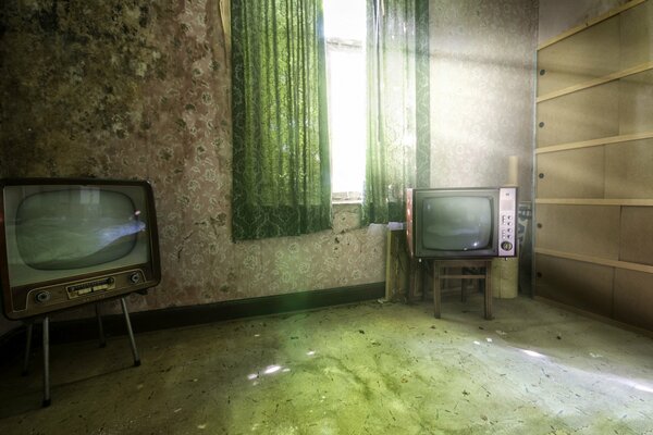 Two old TVs in an empty room