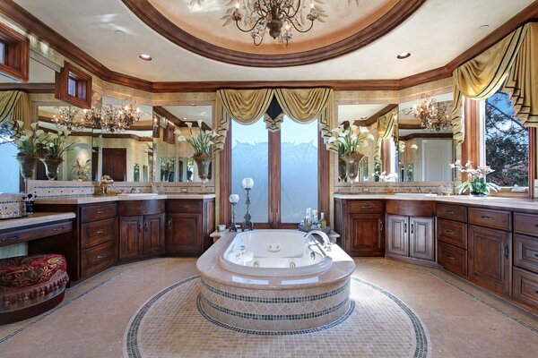 Beautiful designer interior of a bathtub on a mosaic field surrounded by cabinets made of natural wood