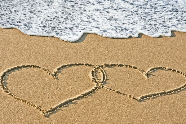 Deux coeurs sur la plage de sable