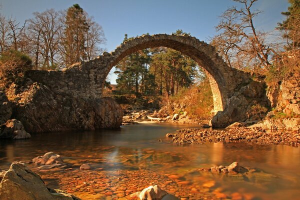 Alte Brücke über dem Fluss im Herbst