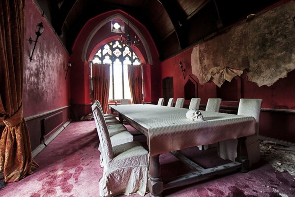 Mesa de banquete en blanco en el salón de terciopelo rosa de un castillo antiguo