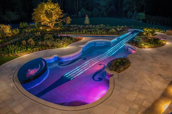 A violin-shaped swimming pool with lighting