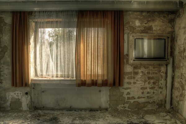 The interior of a stripped concrete room with a large window