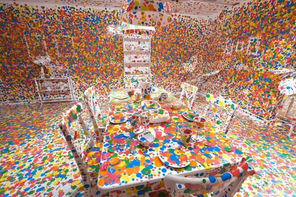 A white room with white furniture decorated with colorful mugs