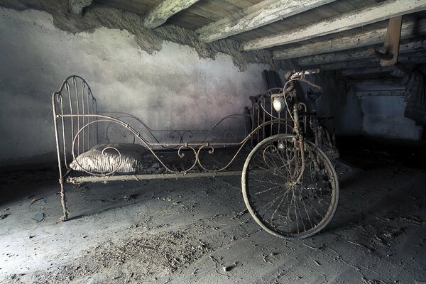 Alter staubiger Dachboden mit Bett und Fahrrad