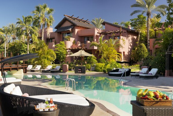 Piscine avec transats sur fond de fourche avec palmiers