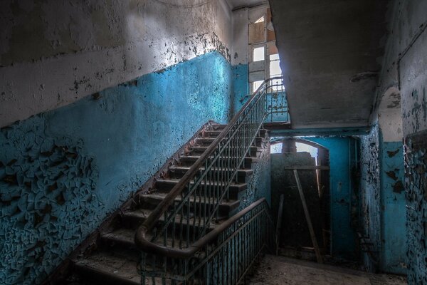 Old entrance with white-blue walls and peeling paint