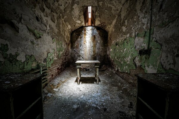 A cell in a damp dungeon with shabby walls