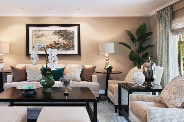 Cozy living room with upholstered furniture. Orchid flowers on the table