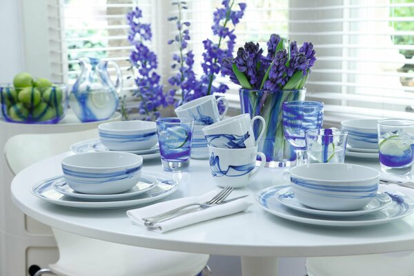 A set of dishes on the table with lilac flowers