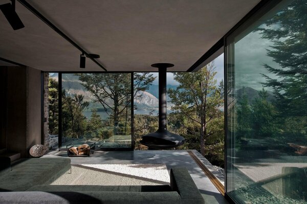 Habitación con chimenea y vistas al bosque