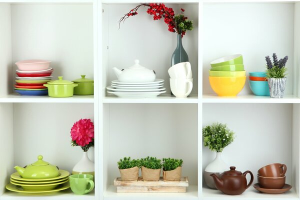 Shelves with dishes, flowers, branches in vases