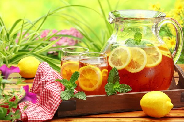 Sommer-Stillleben helle Limonade mit Zitrone in Karaffe und Gläsern