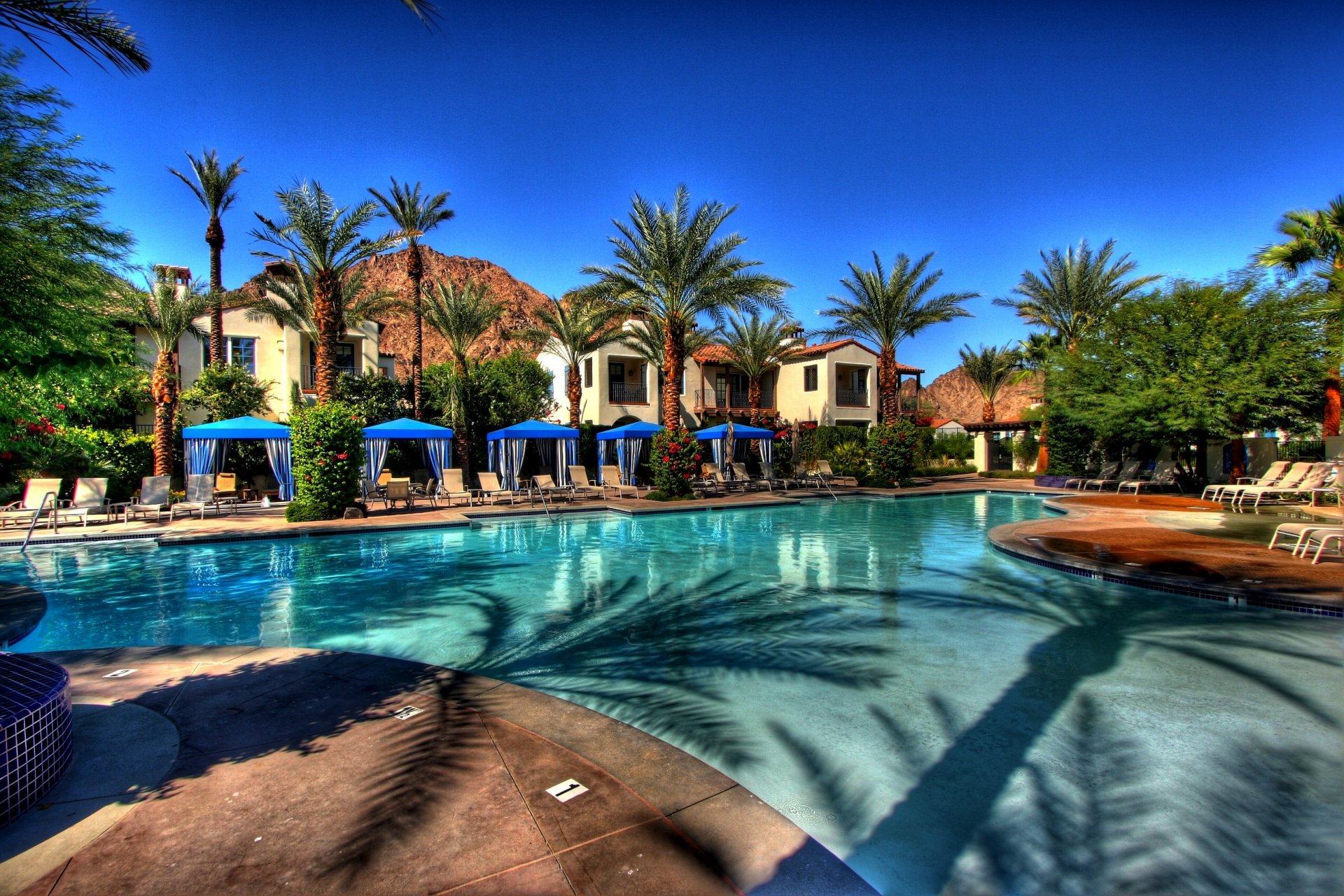 exterior villas houses swimming pool sun beds palm trees