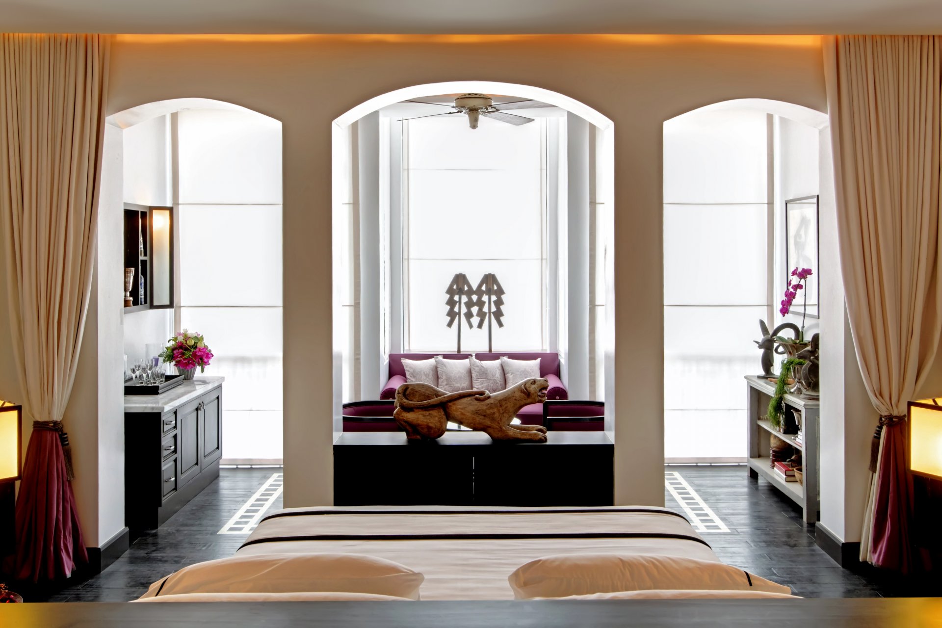 interior suite dormitorio cama lámparas sillones sofá muebles cortinas