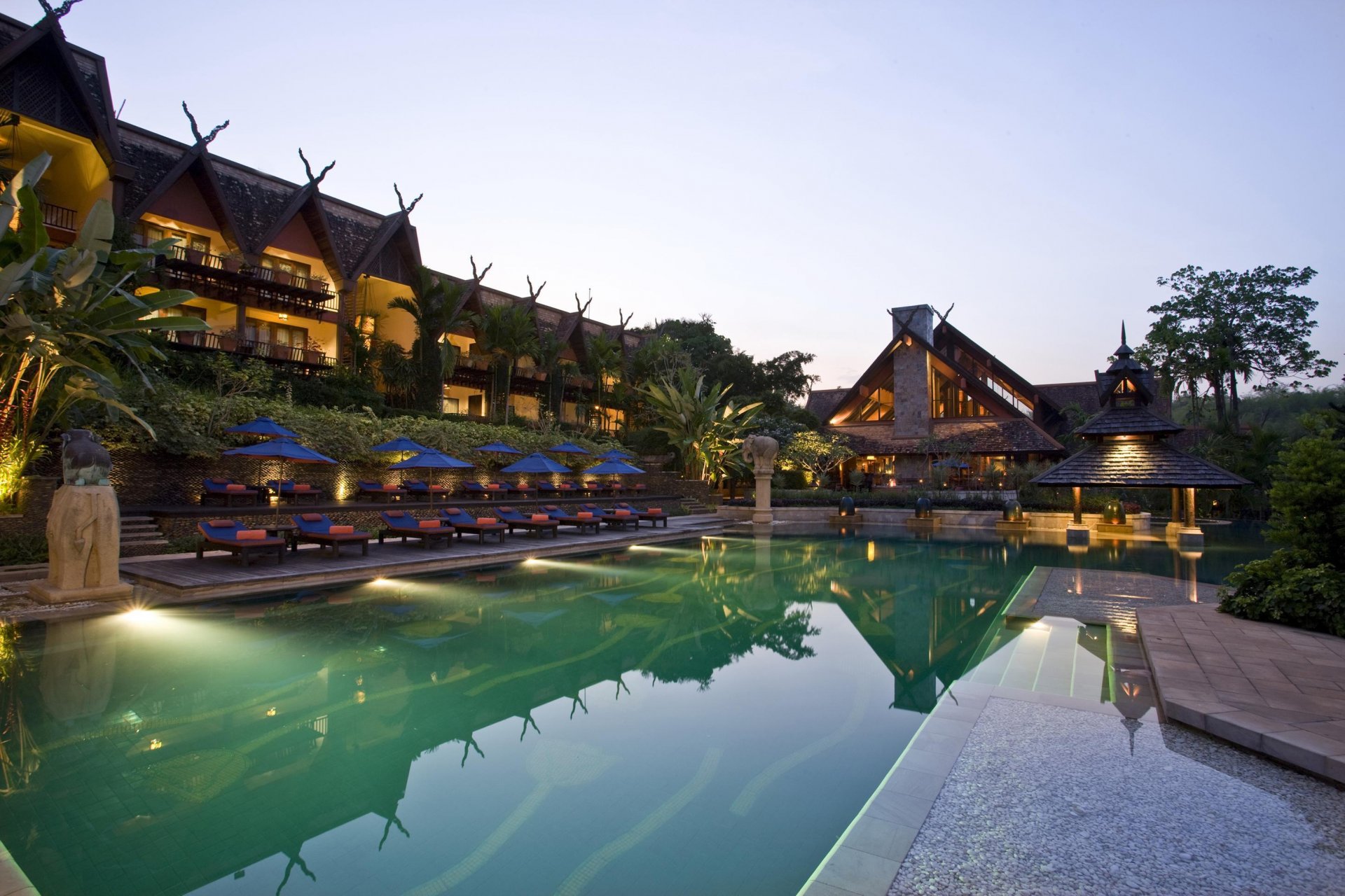 hotel pool exterior palm beds umbrellas