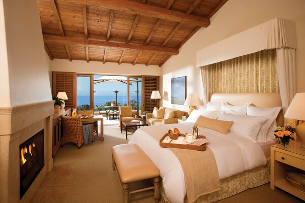 The interior of a luxury room in a resort hotel with a fireplace and access to the terrace