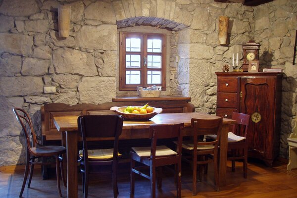 Paredes de piedra y muebles de madera en el interior Mediterráneo