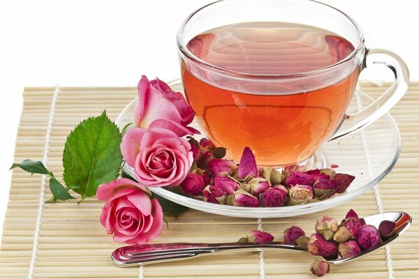 Tazza di tè avvolta con rose e i loro boccioli