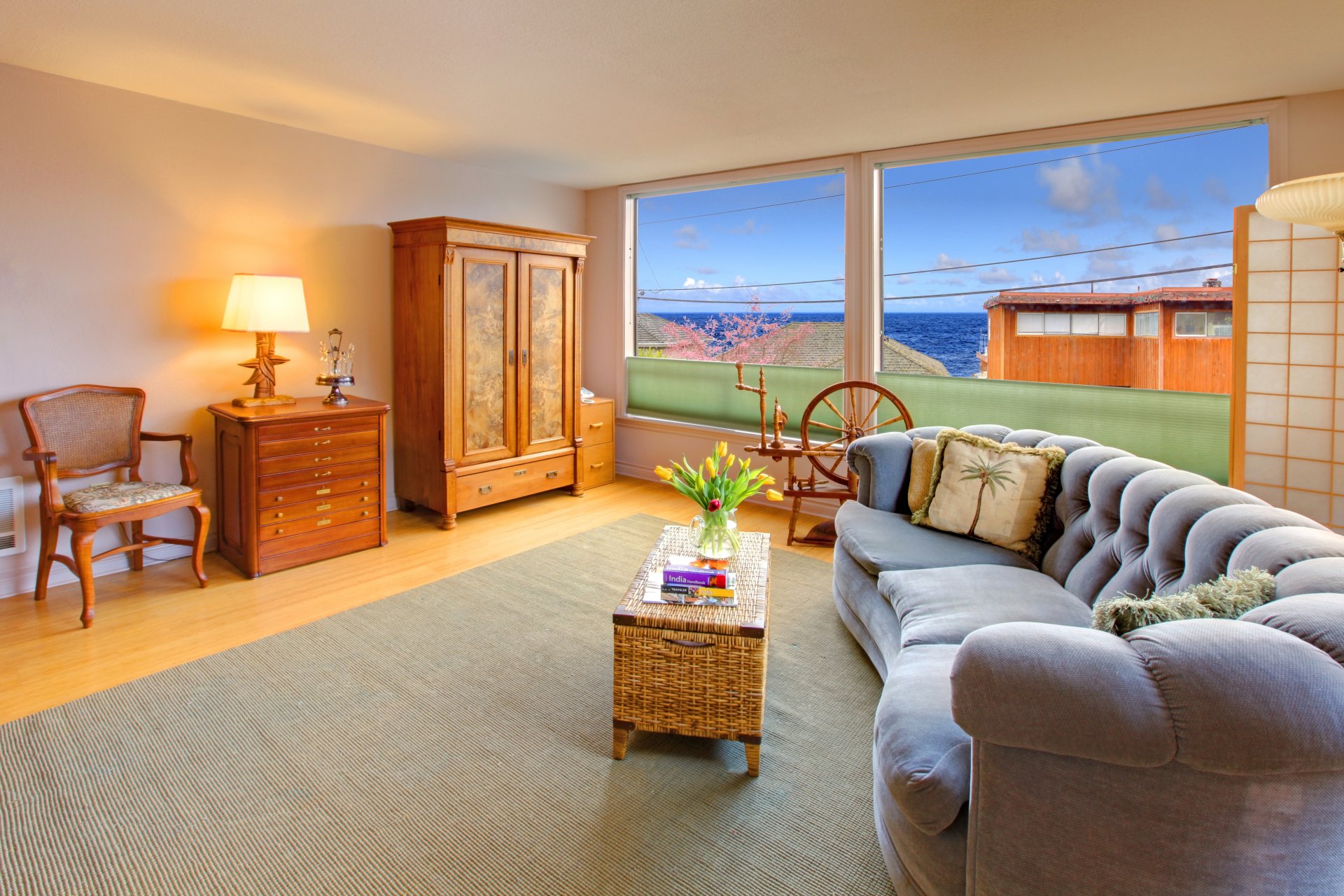 habitación ventanas cielo mar nubes mesita de noche lámpara silla armario mesa florero flores tulipanes libros sofá almohadas