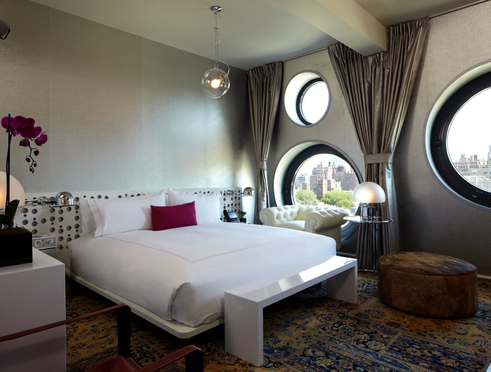 interior estilo dormitorio cama sillón alfombra ventana flores orquídeas
